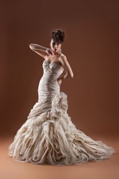 Young beautiful woman in a wedding dress on a studio background