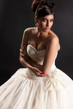 Young beautiful woman in a wedding dress on a black studio background