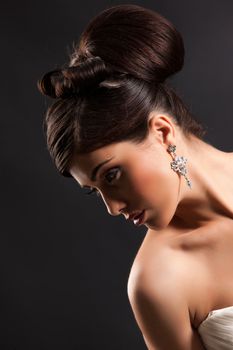 Young beautiful woman in a wedding dress on a black studio background