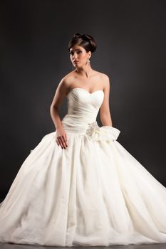 Young beautiful woman in a wedding dress on a black studio background