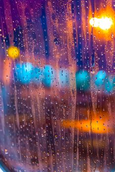 The view from the plane window of the night airport during heavy rain. Selective focus. Blurred image.