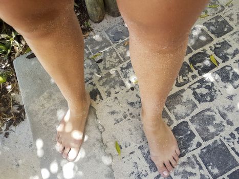 Woman barefoot on sand in Camps Bay.