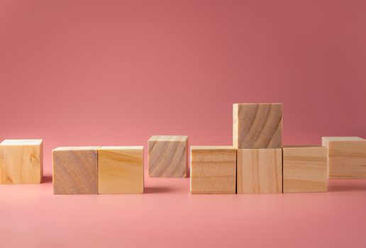 A wooden cube on a pink background. For new ideas to be put into the picture.