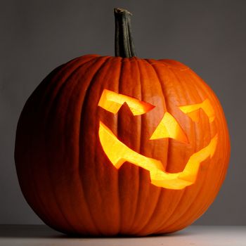 Glowing Halloween Pumpkin on dark background close up