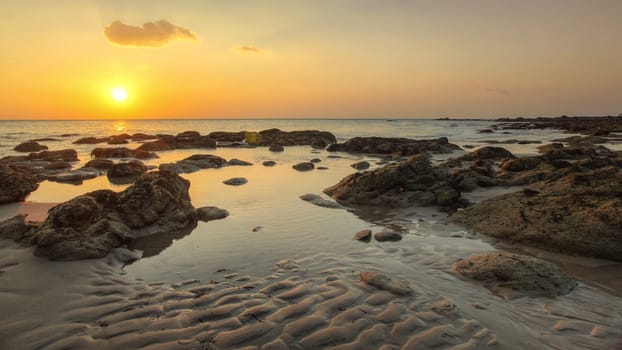 Beach in golden sunset light during low tide showing sand formations and rocks not covered by the sea. Kantiang Bay, Ko Lanta, Thailand.