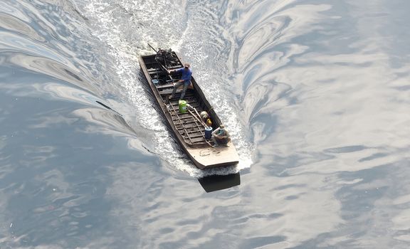 Small old long tailed boat and asia man and sailing in the small river.