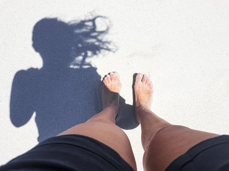 Woman barefoot on sand in Camps Bay, Cape Town.