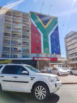 Building or skyscraper, block of flats with a huge South African flag in Cape Town.