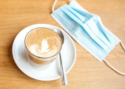 cup of coffee and face mask on the table