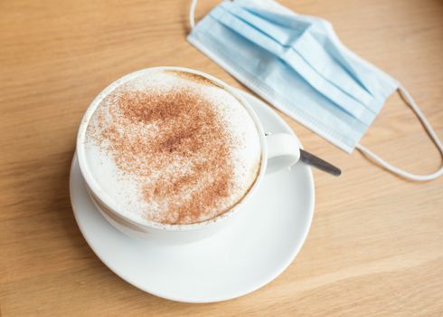 cup of coffee and face mask on the table