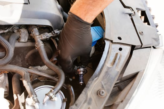 Hand of Man wearing black gloves repairing a car