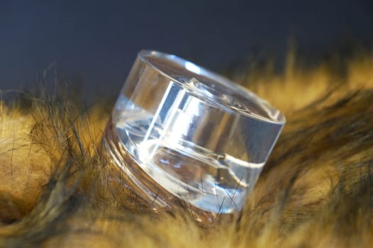 perfume bottle in yellow fur on a black background close-up