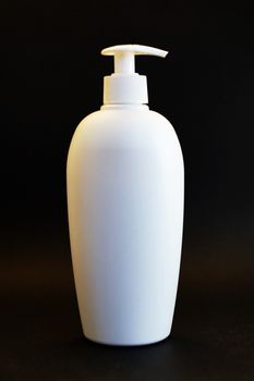 white cosmetic bottle with spray on black background close-up