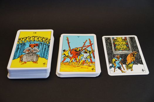 a deck of tarot cards laid out on a black background close-up