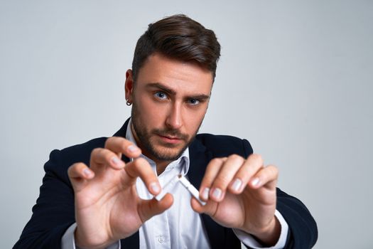 Businessman Business person. Man business suit studio gray background. Modern person breaks a cigarette stopped smoking Portrait of charming successful young entrepreneur