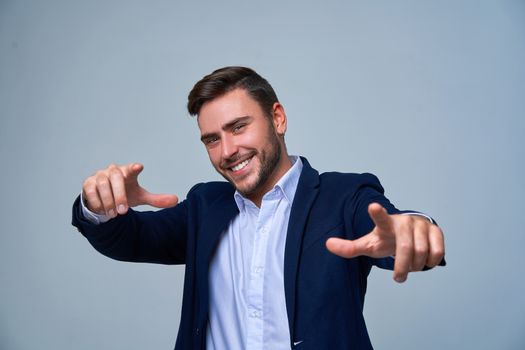 Businessman Business person. Man business suit studio gray background. Modern business person Shows a finger at the camera. Portrait of charming successful happy entrepreneur