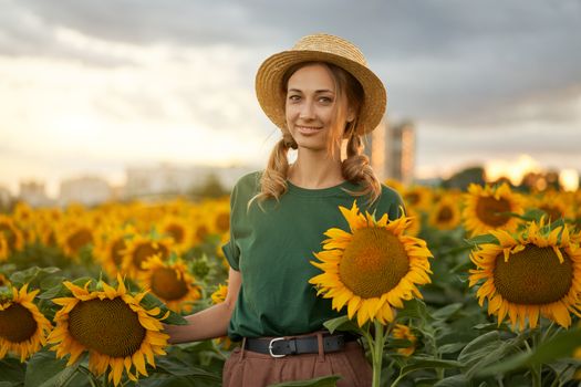 Woman agronomist standing agricultural sunflower field Caucasian female farmer straw hat Portrait agribusiness worker Businesswoman in field planning their income. Farming concept