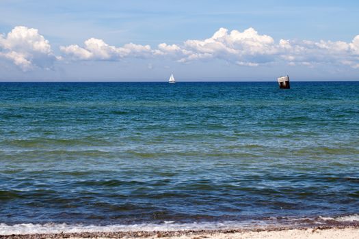 Beach and the Baltic Sea with a sailboat on it