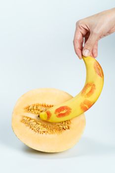 Melon and banana with red lipstick marks on white background, Sex concept.