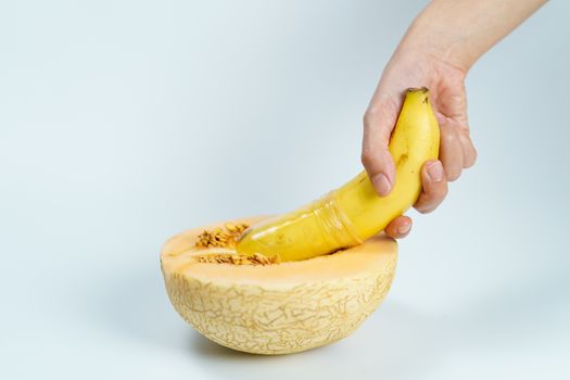 Melon and banana with condom on white background, Sex concept.