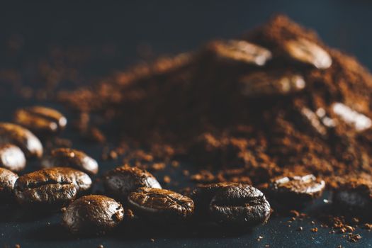 Ground coffee and coffee beans on black background.