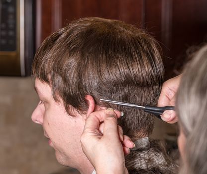 Close up of caucasian man having his hair cut at home during quarantine for coronavirus.