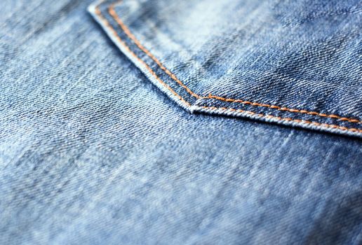 Detail of the denim fabric of a pair of jeans with the seam of the pocket.