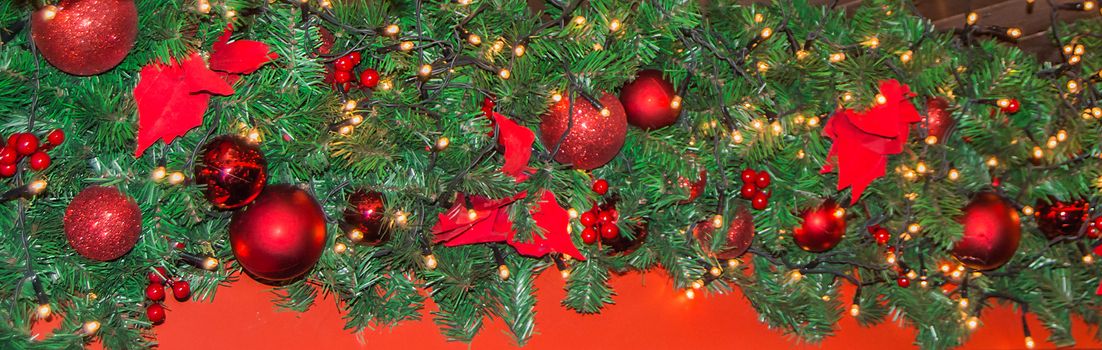 Christmas background banner, garland with spruce branches, balls, lights, decoration.