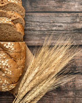 breads sliced and wheat on the sack with a wooden table