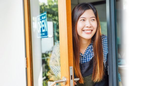 Asian young woman setting open sign at the shop glasses for welcome the customer in to the coffee shop, small business owner and startup with cafe shop, installing open and close label concept