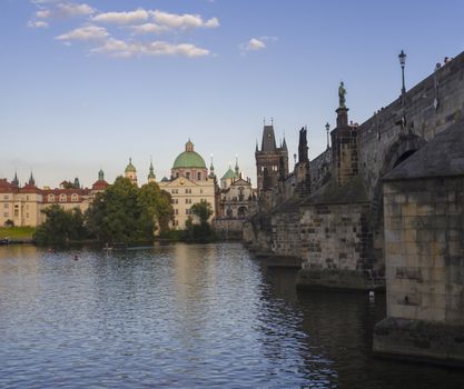 View of Charles Bridge in Prague from Kampa, Czech Republic. Gothic Charles Bridge is one of the most visited sights in Prague. Architecture and landmark of Prague, golden light, sunny summer day.