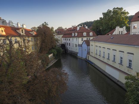Certovka river, Devil's Channel, also called Little Prague Venice between Kampa island and Mala strana in Czech Republic Prague with Historic wooden Mill Wheel, autumn sunny day.