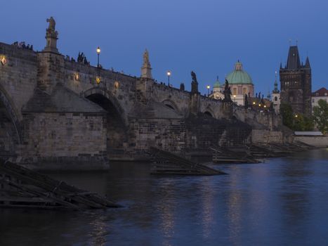 View of iluminated Charles Bridge in Prague from Kampa, Czech Republic. Gothic Charles Bridge is one of the most visited sights in Prague. Architecture and landmark of Prague, night blue hour after sunset.