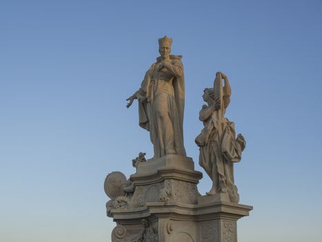Baroque sand stone Statue Saint on Charles Bridge in Prague, Czech Republic, sunny day, clear blue sky.
