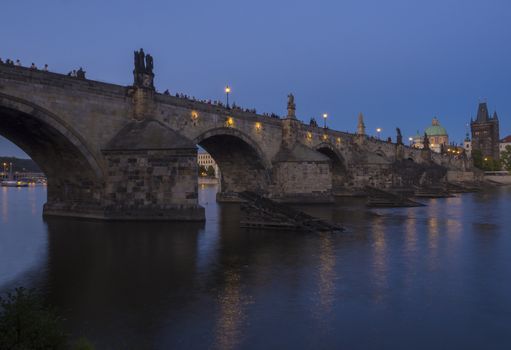 View of iluminated Charles Bridge in Prague from Kampa, Czech Republic. Gothic Charles Bridge is one of the most visited sights in Prague. Architecture and landmark of Prague, night blue hour after sunset.