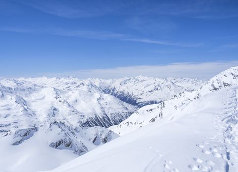 Winter landscape with snow covered slopes and blue sky, view from the top of Kitzsteinhorn mountain on . Kaprun ski resort, National Park Hohe Tauern, Austrian Alps, Europe