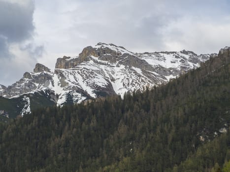 snow covered alpen mountain peaks and forest in Stubaital or Stubai Valley near Innsbruck, Tirol, Austria, dramatic clouds.