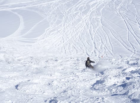 Free ride piste with freerider snowboarder skiing downhill on snow covered slopes from the top of Kitzsteinhorn mountain at Kaprun ski resort, National Park Hohe Tauern, Austrian Alps, Europe. Sunny winter day