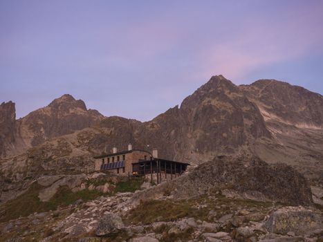 View of the Teryho Chata at sunrise with pink colored mountain peaks and the nature around in the Slovakian mountains High Tatra. This place is very popular by tourists and hikers