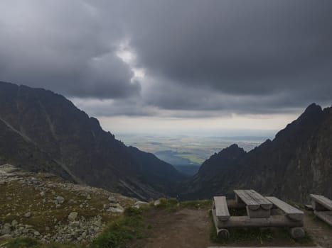 wooden bench and table for eating in the high Tatra mountains in Slovakia with view on valley and foggy sky.