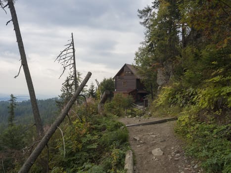 Footpath leading to Mountain Hotel Bilikova Chata, wooden cottage at High Tatra mountain near Stary Smokovec Slovakia, forest and moody sky.