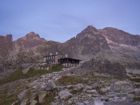 View of the Teryho Chata at sunrise with pink colored mountain peaks and the nature around in the Slovakian mountains High Tatra. This place is very popular by tourists and hikers
