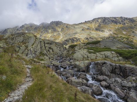 Valley Mlynska Dolina in slovakia mountains with Panoramic view on Strbske pleso village and mountain river stream, High Tatra Mountains, Slovakia, summer day