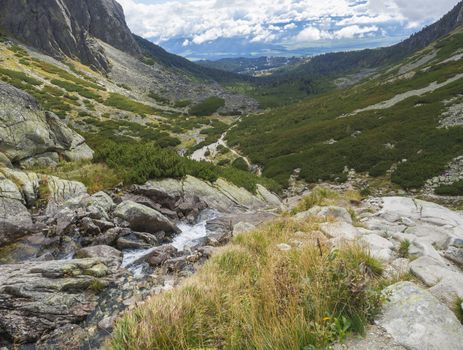 Valley Mlynska Dolina in slovakia mountains with Panoramic view on Strbske pleso village and mountain river stream, High Tatra Mountains, Slovakia, summer day