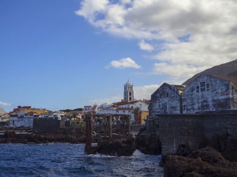 village center of Garachico panorama with sea rocka Church of Santa Ana and old fisherman dock buildings in Tenerife canary island spain and blue sky white clouds