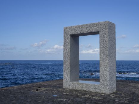 Spain, Canary islands,Garachico, December 19, 2017, marble monument statue sqare frame shape on the pavement bank with blue sky and sea background