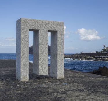 Spain, Canary islands,Garachico, December 19, 2017, marble monument statue on the pavement bank with blue sky and sea background