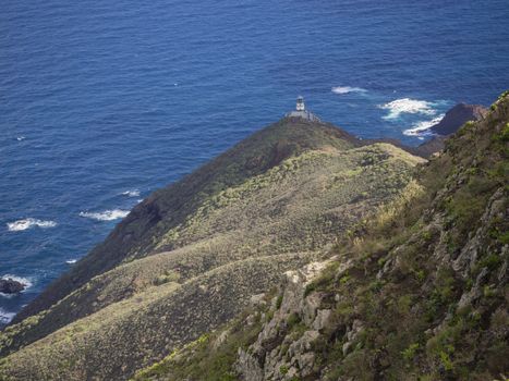 view on Faro de Anaga lighthouse with green hills  blue sea atlantic ocean scenery in anaga mountain, tenerife  canary island spain