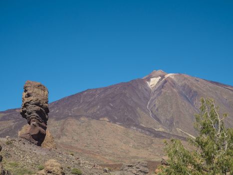 view on Roque Cinchado and colorful volcano pico del teide highest spanish mountain from famous rock formation Roques de Garcia with clear blue sky