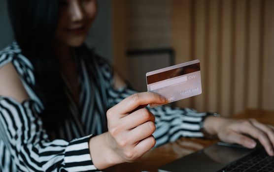 close up woman using laptop and credit card for pay online shopping e-commerce online payment concept